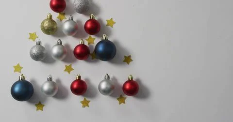 Displaying triangular red silver blue gold baubles with metal caps on white Stock Photos