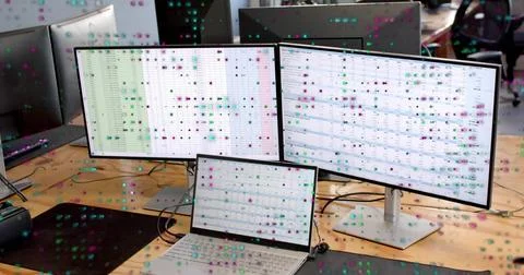 Displaying two external monitors and laptop showing spreadsheets at open-plan 스톡 사진