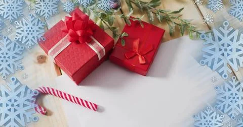 Displaying two red gift boxes on wood tabletop, with candy cane, evergreen 스톡 사진