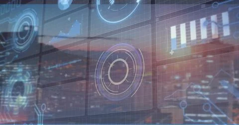 Displaying UI with circular HUD and charts over window showing dusk city skyline Stock Photos