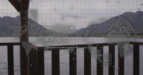 Displaying world map and code overlay over lakeside deck railing, framing lake 库存照片