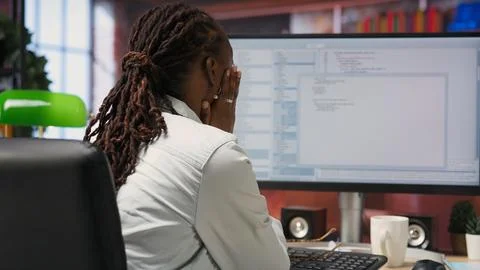 Displeased IT worker seeing errors while using coding application Stockfoto's