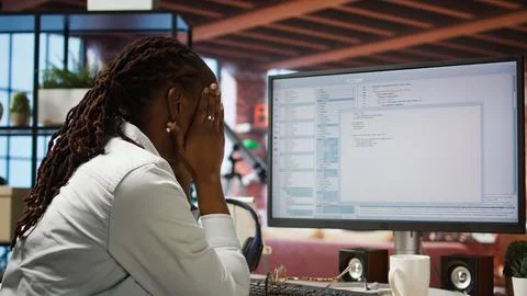 Displeased IT worker seeing errors while using coding application Stock-Fotos