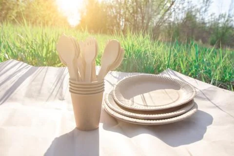Disposable biodegradable tableware on craft paper in nature. Stock Photos