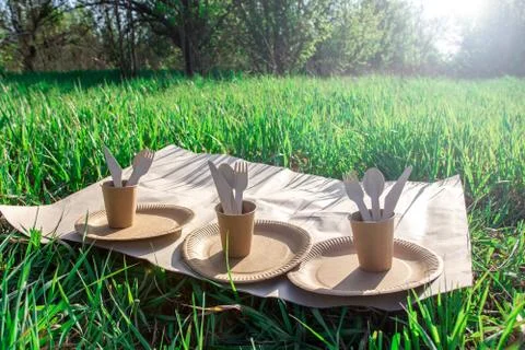Disposable biodegradable tableware on craft paper in nature. Stock Photos