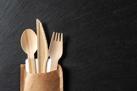 Disposable biodegradable tableware made of wood spoon, knife and fork on marble Stock Photos