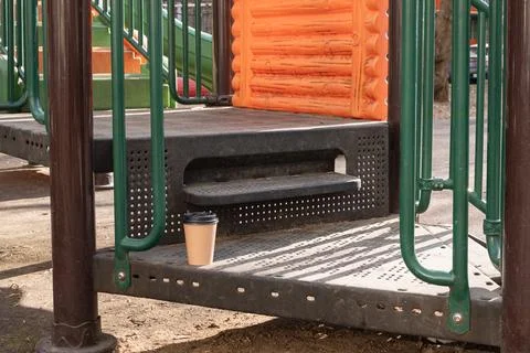 Disposable coffee cup left on a playground platform Stock Photos