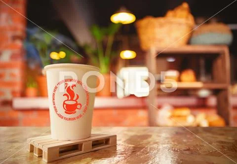 Disposable coffee cup on table in café PSD-Vorlage