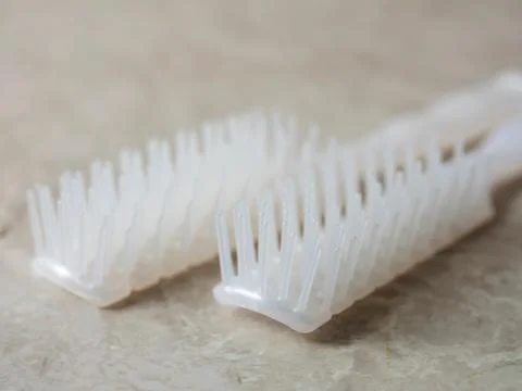 Disposable comb on a gray background Stock Photos
