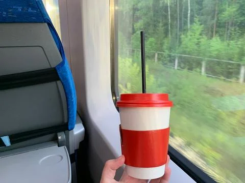 Disposable Cup in Hands on the Train. Window of train. Template for an text.. Stock Photos