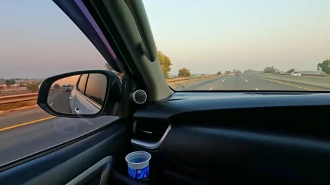 Disposable cup sitting inside the vehicle cup holder while driving on highway. Stock Footage 340855274