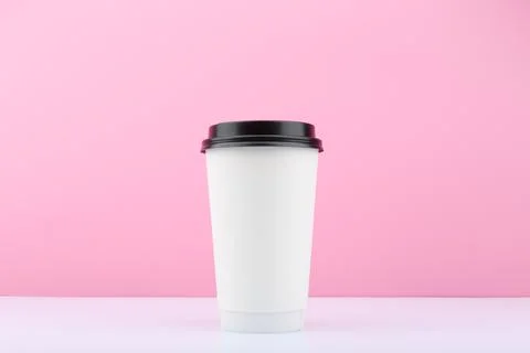 Disposable cup for tea or coffee on white table against bright purple background Stock Photos