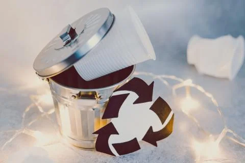 Disposable cups and garbage bin with recycle symbol, concept of reducing sing Stock Photos