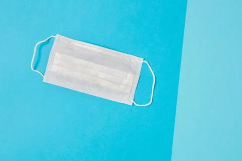 Disposable face mask on blue background. Stock Photos