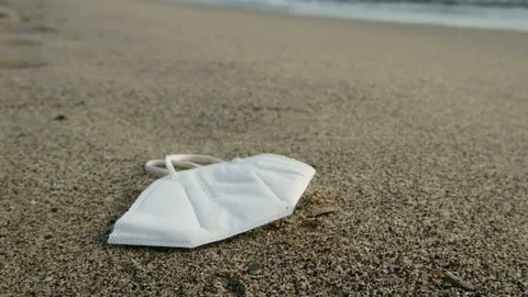 Disposable face mask falling down on dirty sea shore,covid19 pollution Stock Footage 152859847
