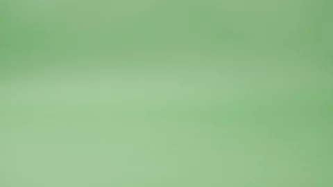 Disposable paper tableware falls from above and riding on a green background. Видео 127660762