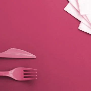 Disposable plastic cutlery. Plastic fork and knife Image toned in Viva Mage.. Stock Photos
