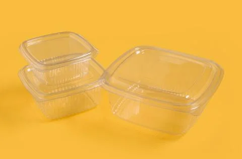 Disposable plastic food containers on yellow background, closeup Stock Photos
