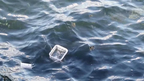 Disposable plastic utensils float on sea waves. Stock Footage 150211706