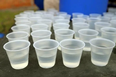 Disposable plastic water cups on table Stock Photos