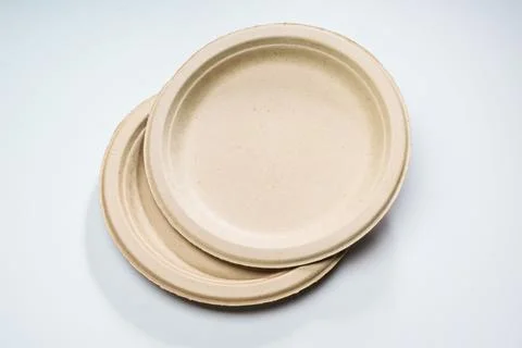 Disposable plates made of vegetable raw materials lie on the table Stock Photos
