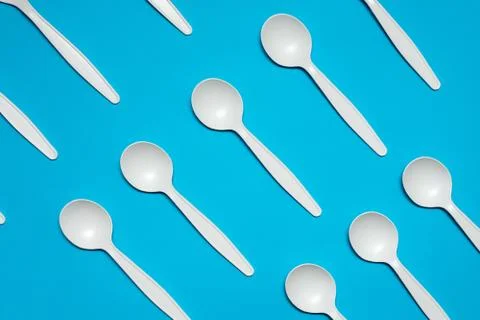 Disposable spoons of corn starch on a blue background. Stock Photos