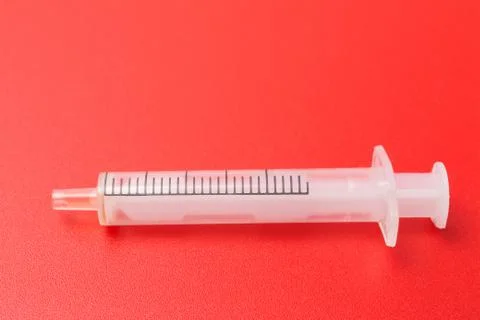 Disposable syringe on red background Stock Photos