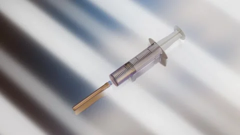 Disposable syringe rotates on silver background with backlight. 3d render looped Stock Footage 301515063