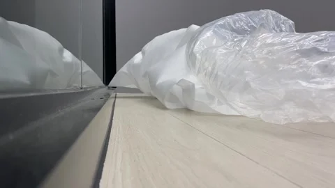 Disposable white plastic wrap on floor close up shot indoor low angle view. Stock Footage 253248653