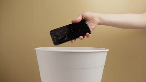 Disposal of old technology, the hand throws the used phone into the trash, .. Stock Footage 271173859