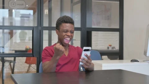 Dissatisfied Casual African Man Using Phone at Workplace Video stock 303216028
