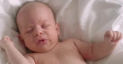 Dissatisfied, crying, upset, sad Newborn baby boy lying in nursery in crib with 스톡 동영상 249112892