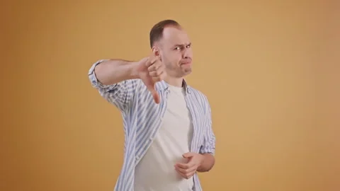 Dissatisfied man posing with thumbs-down negative sign about failure Stock Footage 288874621