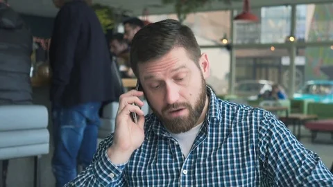 Dissatisfied man talking by smartphone, arguing, cafe, portrait, steadicam shot 库存影片 72947156