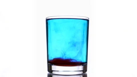 Dissolving of a red pigment into cyan colored water glass using a glass stick Stock Footage 159483214