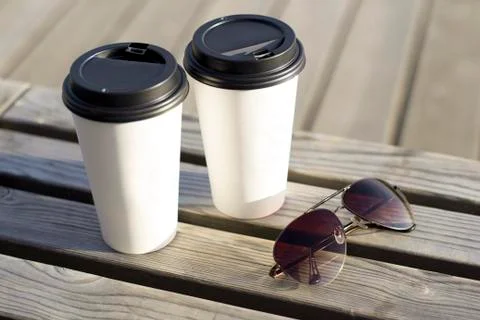 Dissposable cups of coffee on a bench Stock Photos