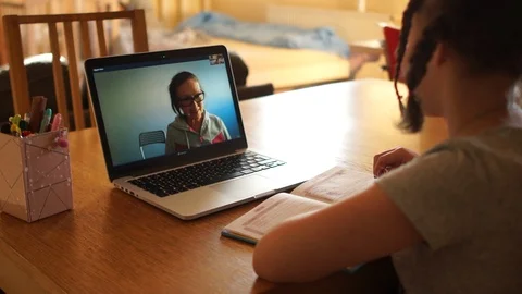 Distance learning during quarantine coronovirus covid-19. A cute schoolgirl with Stock Footage 129394967