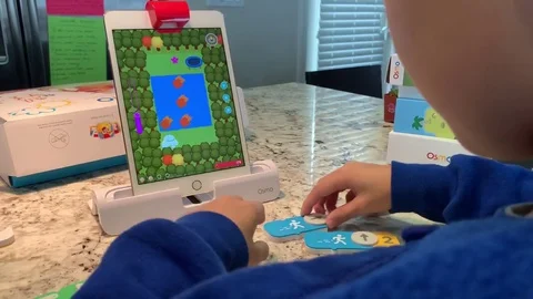 Distance Learning. Home schooling. Child playing the OSMO coding game on Stock Footage 128473922