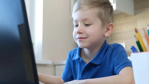 Distance learning online education. Cute caucasian boy doing homework on a Vidéo 127214163