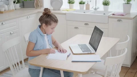 Distance learning online video chat with a teacher. A schoolgirl is studying at Vidéo 142937775