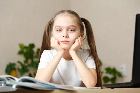 Distance or remote learning. Pupil want to sleep. Tired schoolgirl with hand  Foto stock