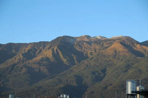 In the distance, there is an endless mountain range with snow on top and gr.. Stock Photos