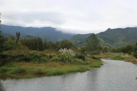 In the distance, there is an undulating mountain range with white clouds fl.. Stock Photos