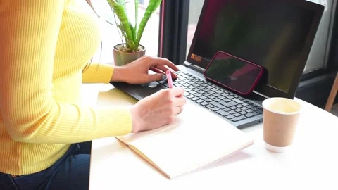 Distance work, woman taping computer  and makes notes at cafe. Freelance .Busine Stock Footage 237716128