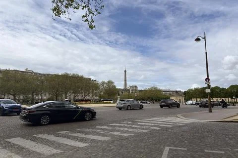 Distanced view of the Eiffel Tower from a Parisian street with city traffic a 스톡 사진