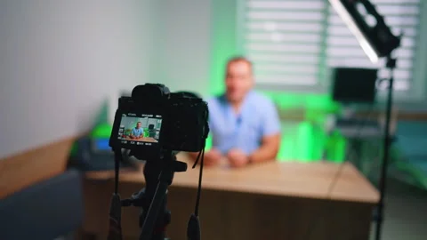 Distancing from camera directed on the man sitting at the desk. Display of Stock Footage 334339225