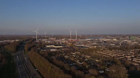 Distant aerial approach to wind turbines and port in warm evening light Stock Footage 335651610