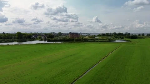 A distant aerial view of a medieval castle surrounded by water, lush green 库存影片 314784512