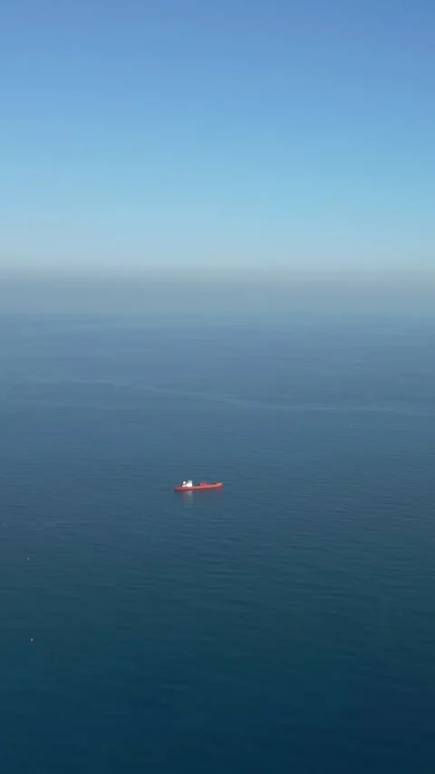 Distant Aerial View of Red Cargo Ship Anchored in Open Mediterranean Sea Video stock 318921590