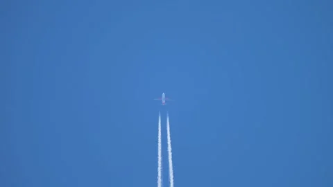 Distant airliner producing long symmetrical contrails against clear atmosphere Vidéo 339281162